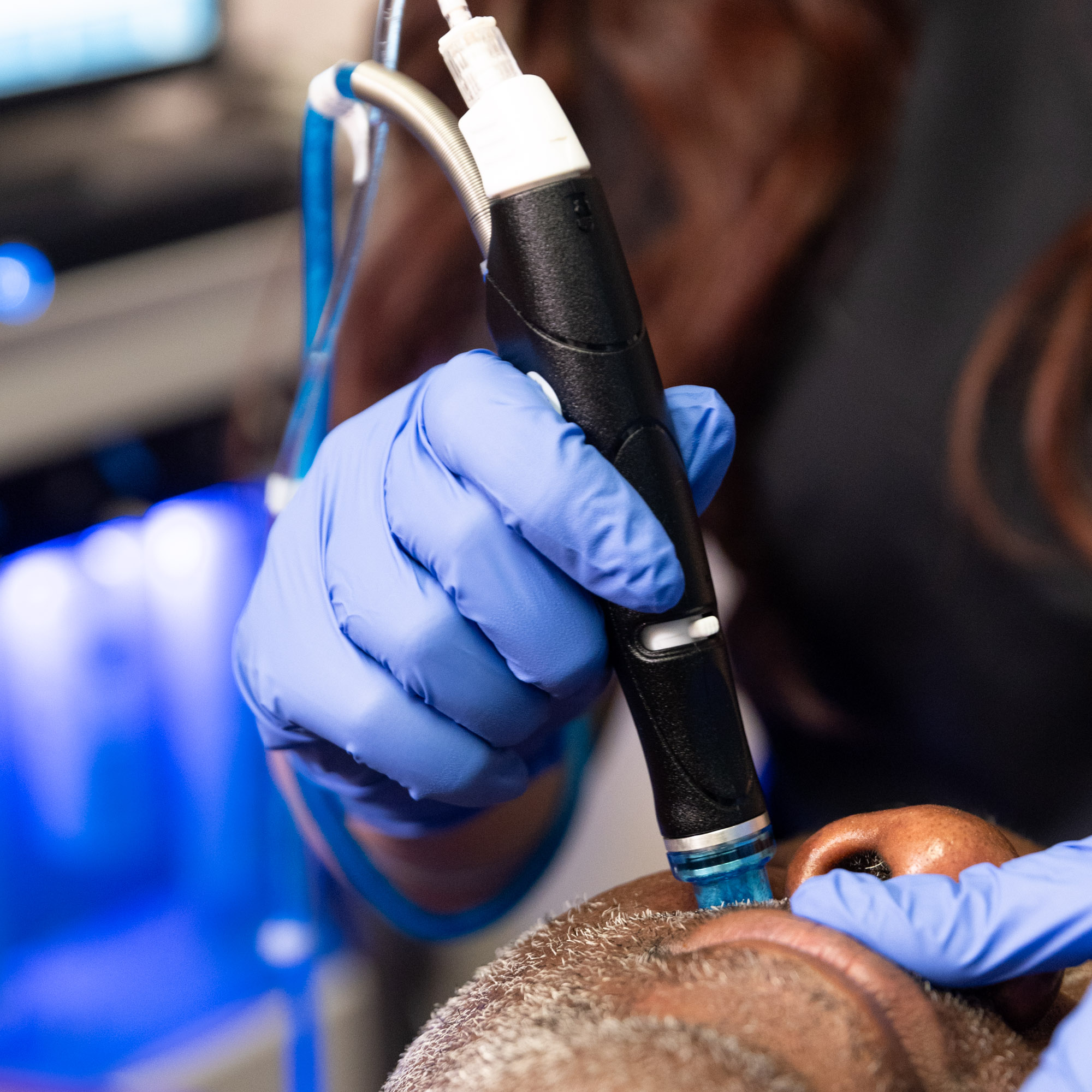 A provider in surgical gloves performs a Hydrafacial for skincare in Marlton, NJ