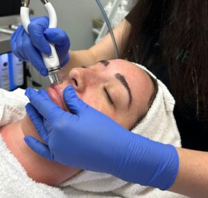 A patient shuts her eyes as a provider performs skincare in Marlton, NJ