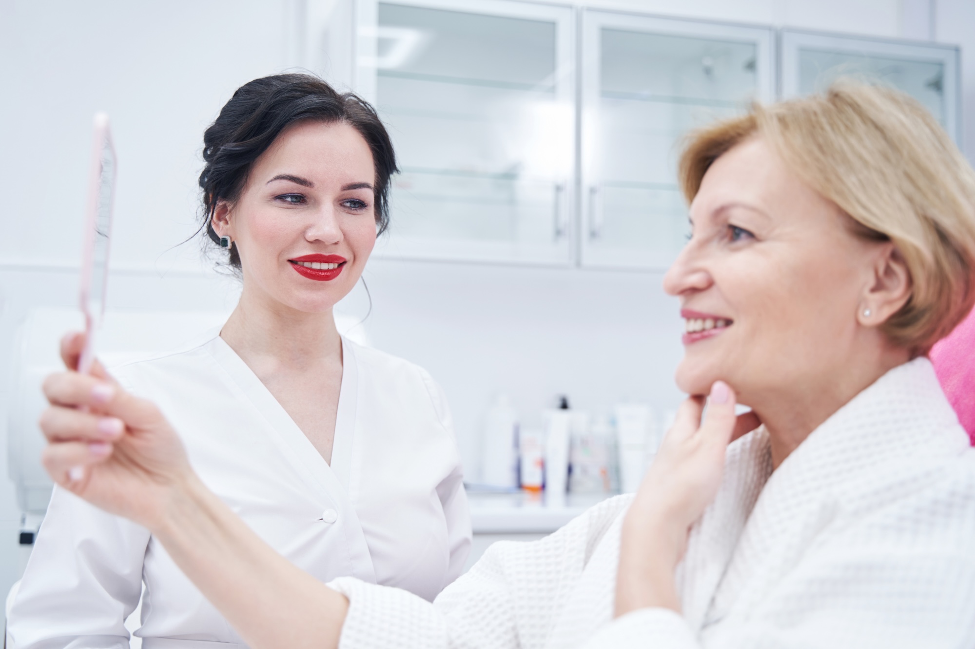 mature female bonde patient at Vive Aesthetics & Wellness looking at her results after receiving Botox near Moorestown, NJ.