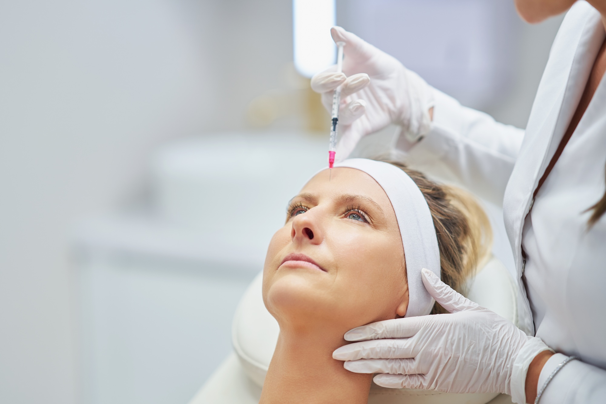 A female provider at Vive Aesthetics & Wellness administering another female patient's botox injections near Medford, NJ.