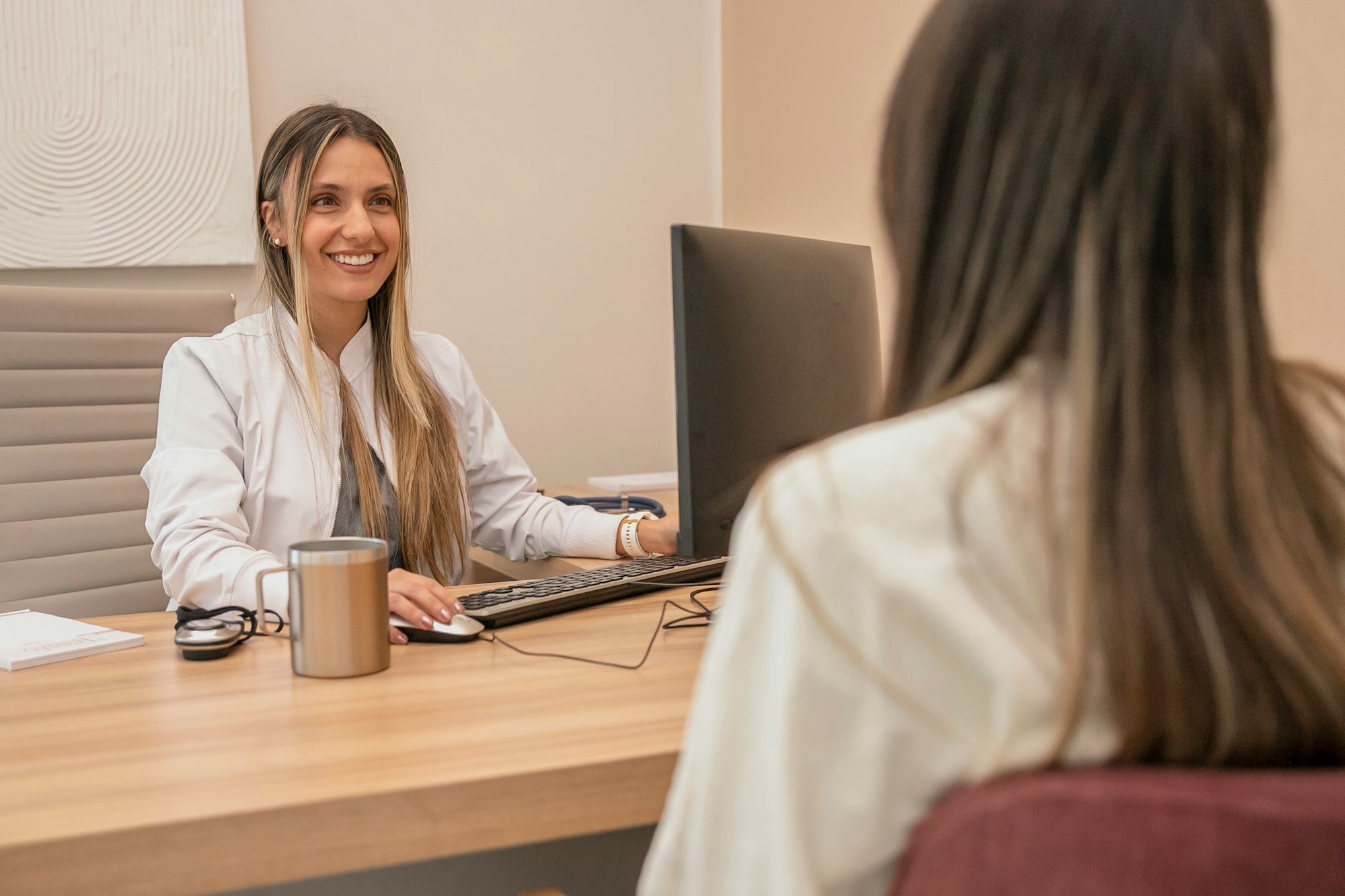 A provider smiles at a patient while discussing body sculpting near Cherry Hill, NJ.